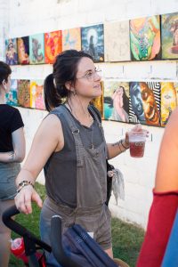 Woman Looking at Art with her Beer at Black Amethyst Tattoo Gallery Art Show
