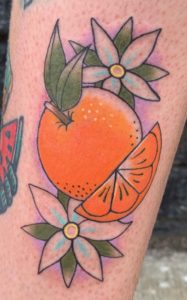 Orange and Flowers Tattoo by Shannon Haines at Black Amethyst Tattoo Gallery.