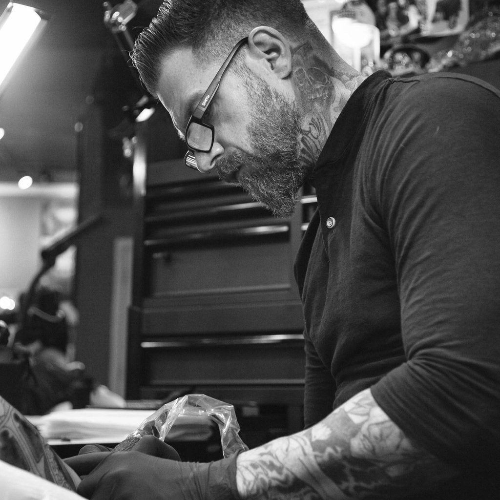 Alt text: Black Amethyst artist working on a custom tattoo design in St. Pete